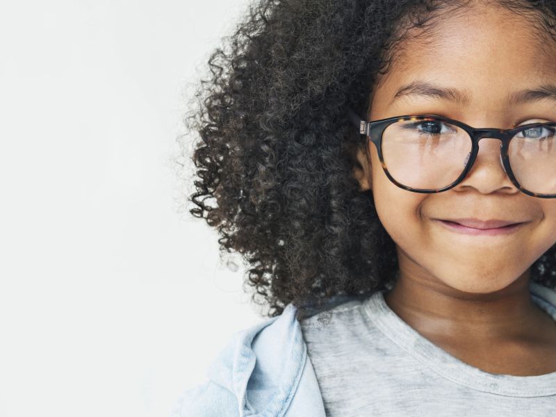 ein Mädchen mit Brille und Lächeln